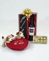 Caja con accesorios y vino, peluche, bombones.